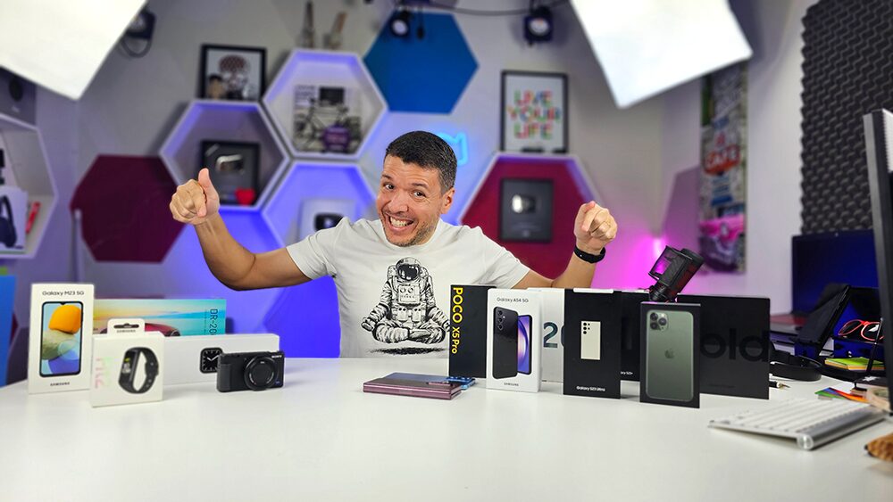 Everton Vianna em estúdio de gravação apresentando smartphones e gadgets para reviews de tecnologia
